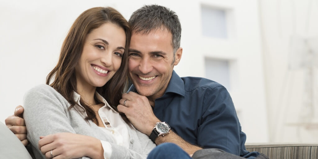 Happy Couple Sitting On Couch