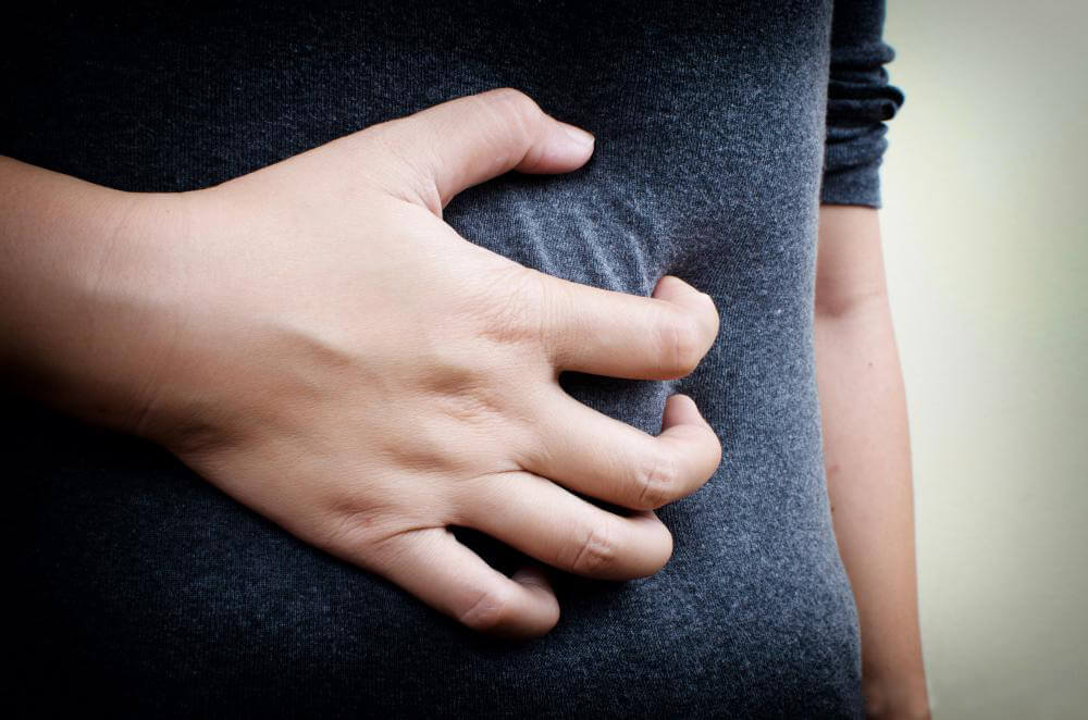 closeup-grabbing-stomach-pain