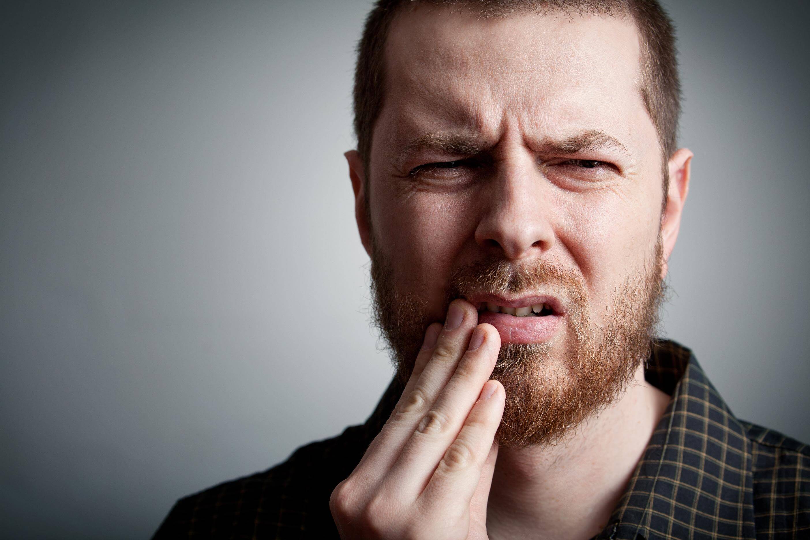 Toothache - suffering young man with teeth problems